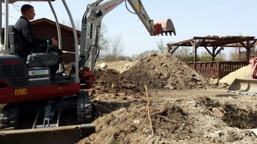 Minibagger bei Erdarbeiten im Garten – Aushub und Bodenabtrag auf einem privaten Grundstück