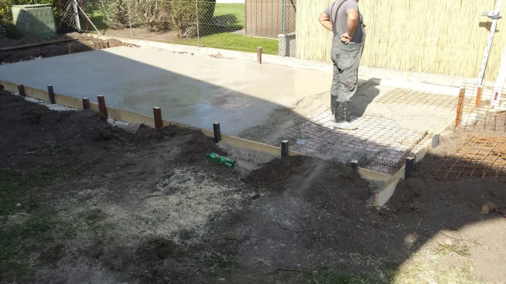Frisch gegossene Bodenplatte mit Bewehrung – Vorbereitung für Betonarbeiten von Rauner