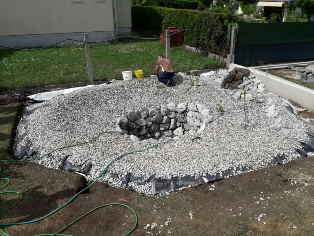 Teichbau mit Natursteinen – Grundbau für Wasserfall und Gartenteich vor Befüllung