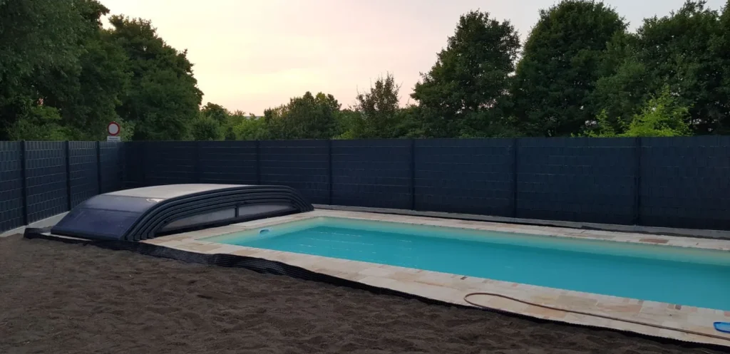 Fertiger Pool mit Zaun, umliegender Boden vorbereitet für Rollrasen