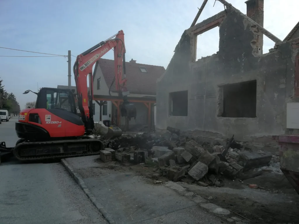 Gebäudeabriss mit Bagger – Rückbau eines Mauerwerks im Rahmen von Abrissarbeiten oder Sanierung