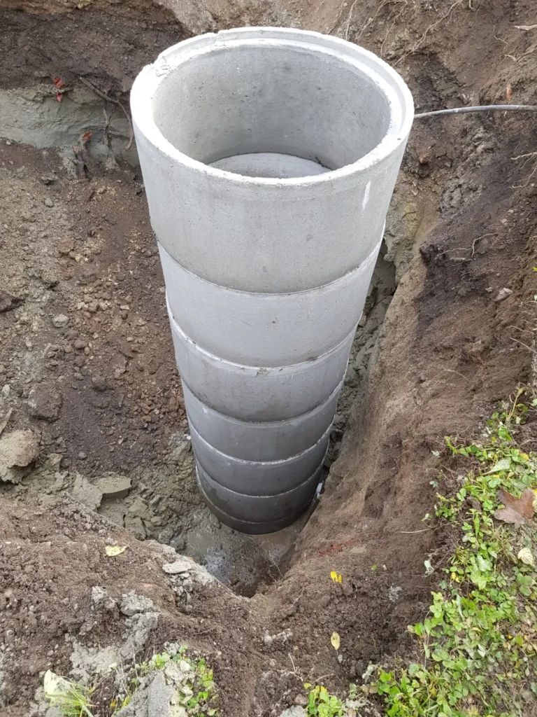 Eingesetzter Betonringschacht in Baugrube – Vorbereitung für Brunnen oder Entwässerungssystem
