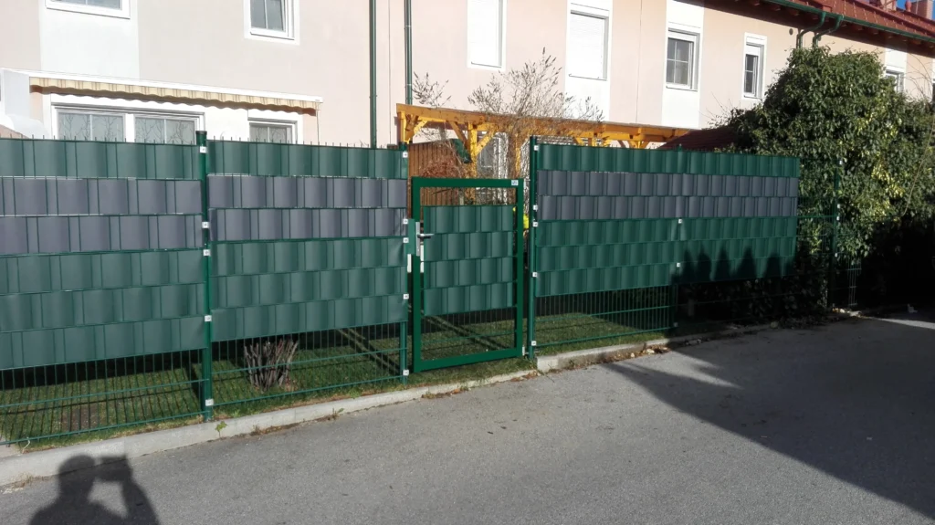 Doppelstabmattenzaun mit Sichtschutz und Gartentor – Beispiel für Zaunbau im Wohnbereich