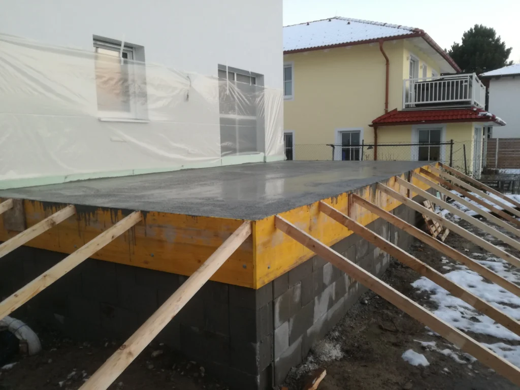Frisch gegossene Betonplatte mit Schalung – Fundament- und Betonarbeiten von Rauner am Wohnhaus