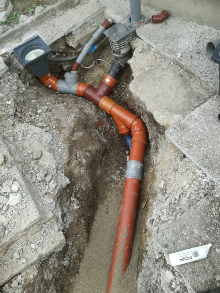 Verlegte Abfluss- und Drainagerohre mit Kontrollschacht – Sanierung oder Neuverlegung im Erdreich