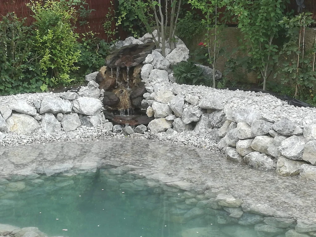 Wasserfall aus Naturstein als Teil eines Gartenteichs – eingebautes Element zur Teichgestaltung
