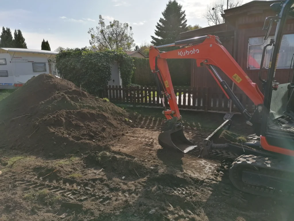 Minibagger bei Erdarbeiten im Garten – Aushub und Bodenabtrag auf einem privaten Grundstück